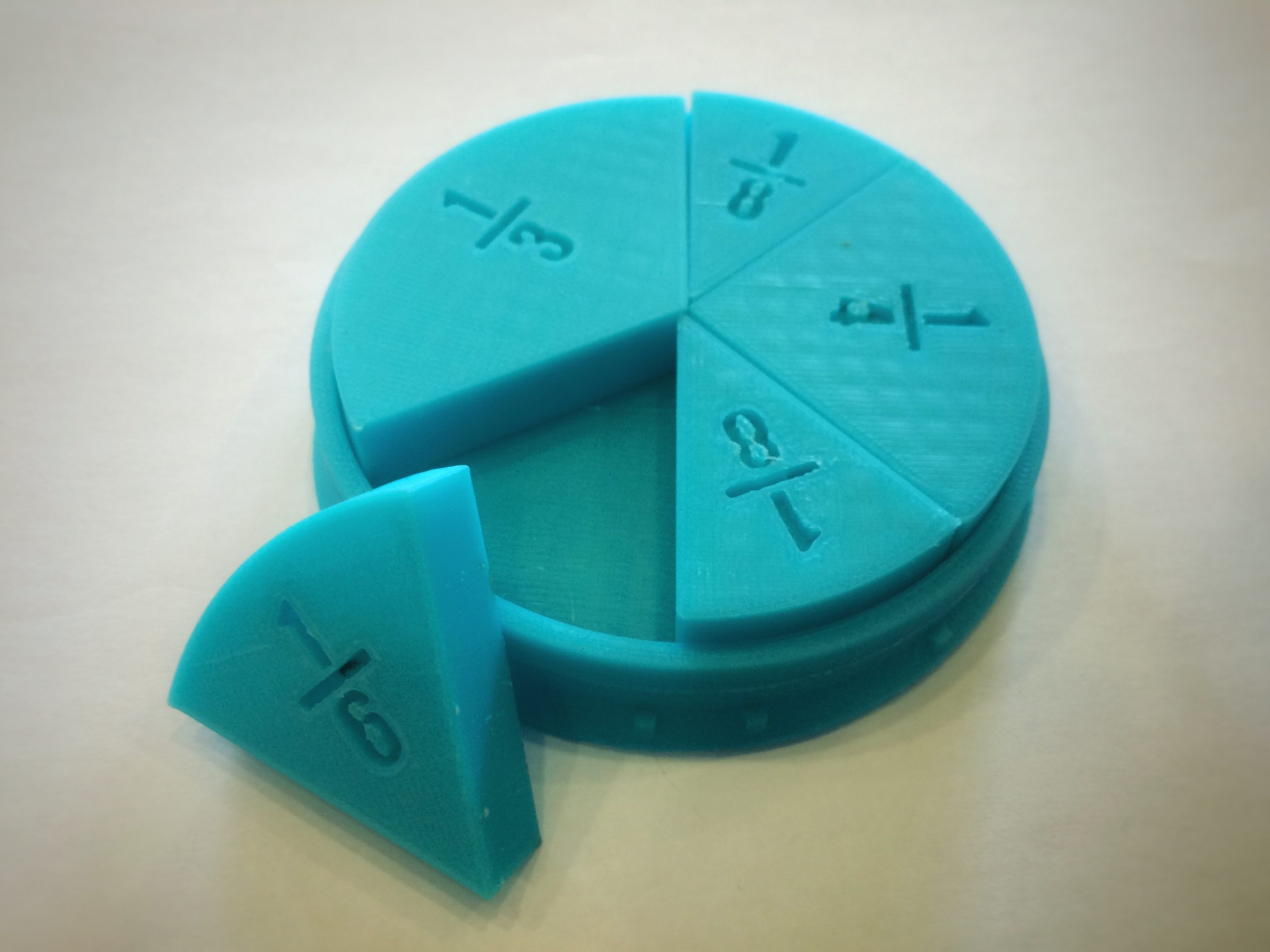 A close up photo of a plastic 3D printed object in aqua plastic. The object is a math teaching aid.