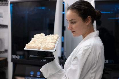 A photo of a dental technician removing a build platform from the XiP Pro 3D printer